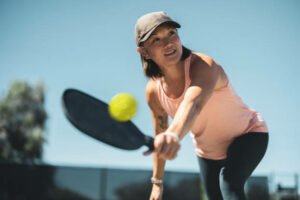 Player hitting a pickleball groundstroke on an outdoor court